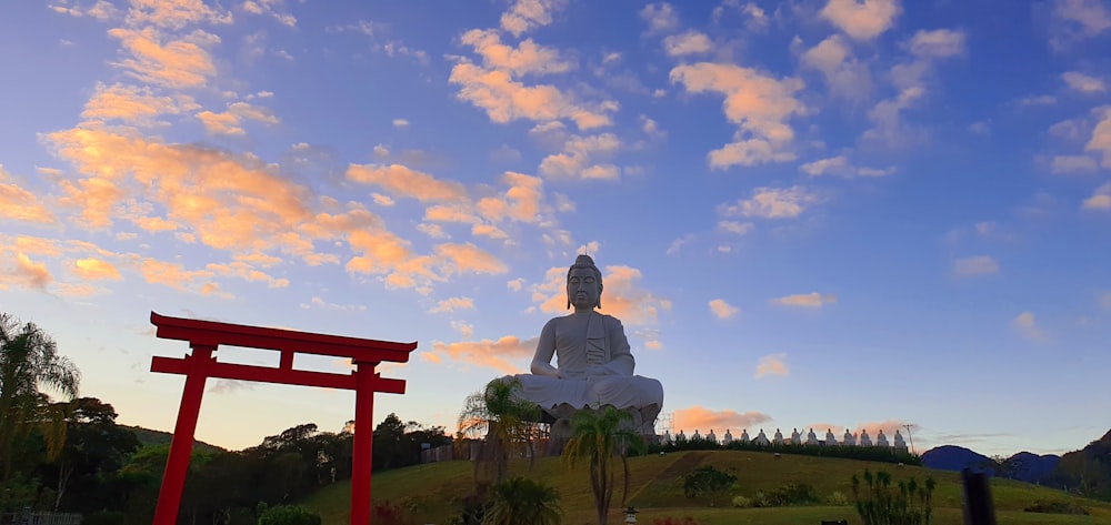 man statue on green grass field under blue sky during daytime