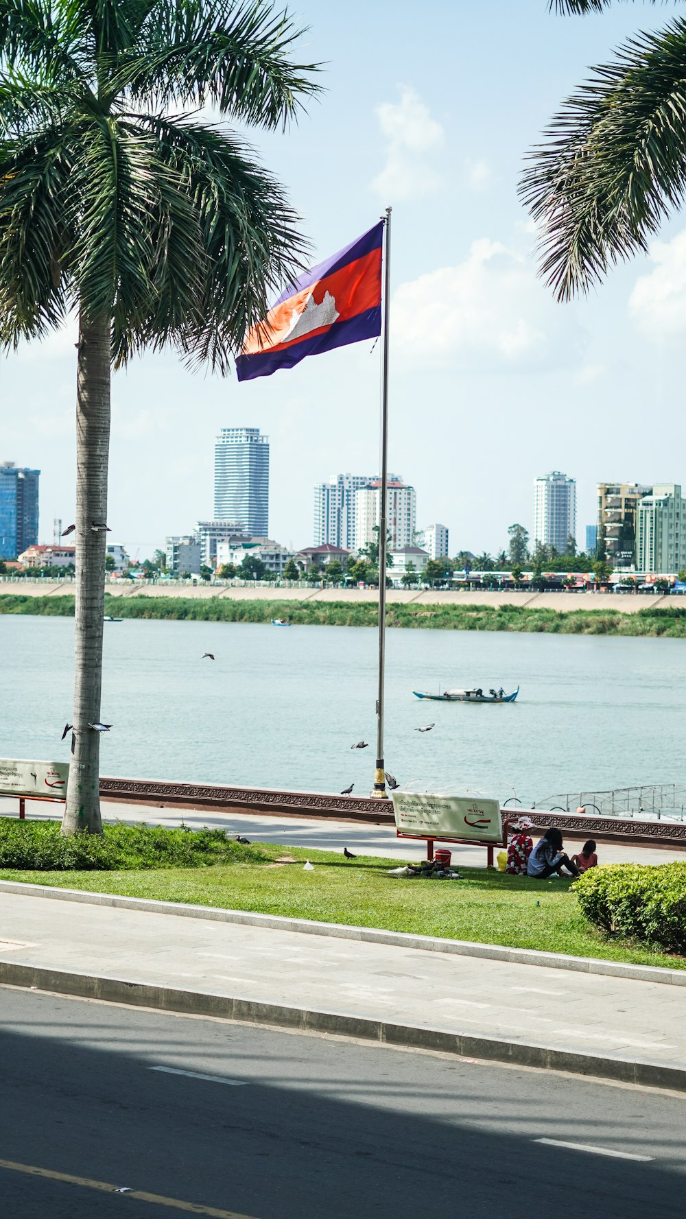 people sitting on bench near body of water during daytime