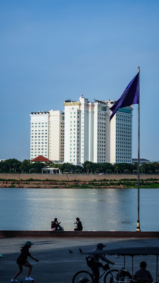 white and blue flag on pole near body of water during daytime in Royal Palace Park Cambodia