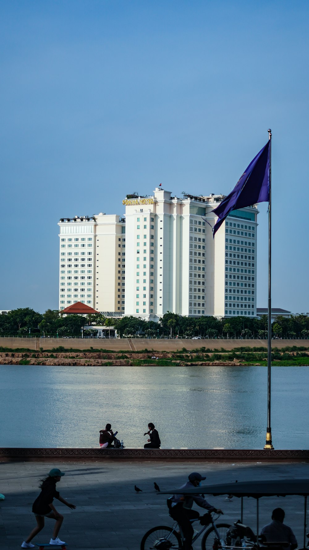 white and blue flag on pole near body of water during daytime