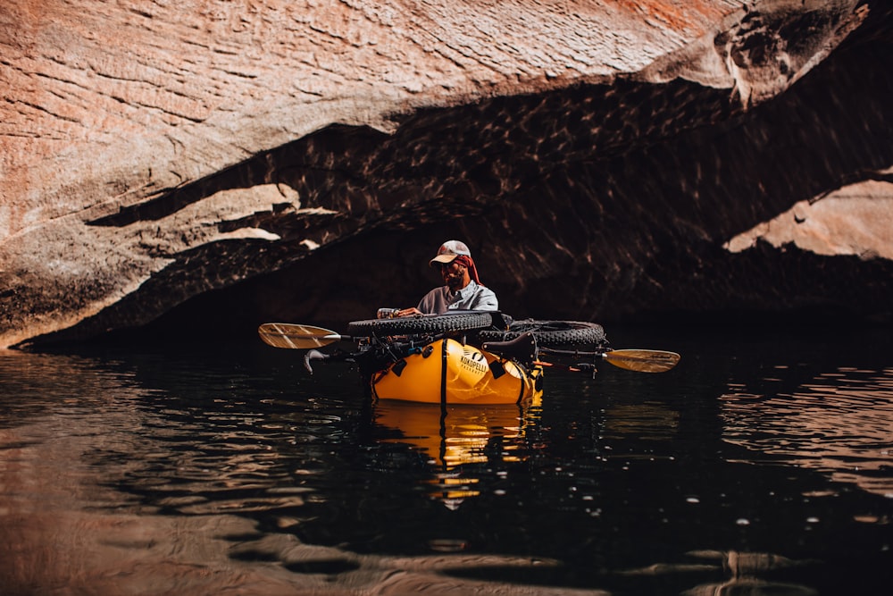 man in black and white striped shirt riding yellow kayak on river during daytime