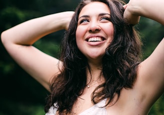 woman in white tank top smiling