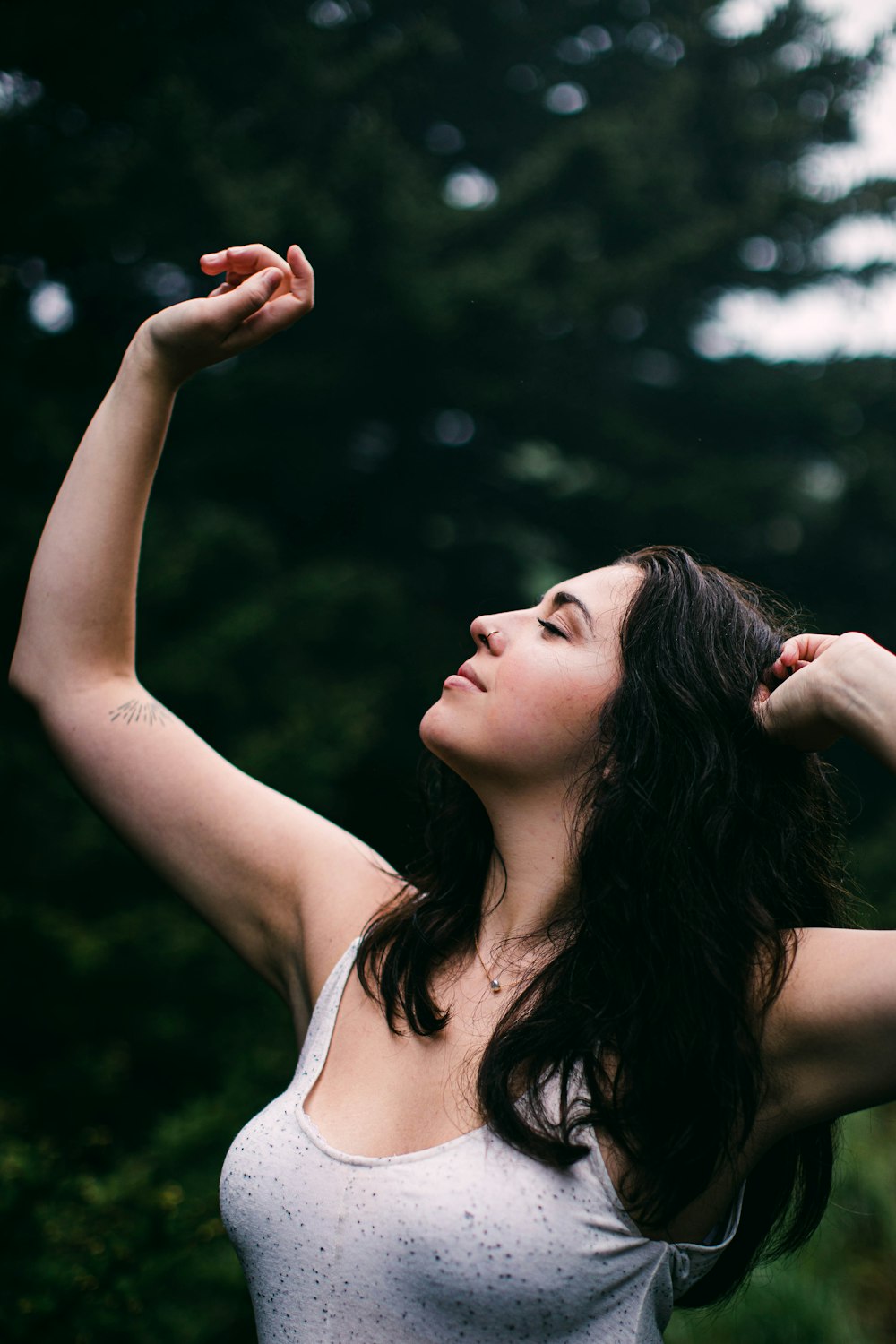 woman in white tank top holding her hair