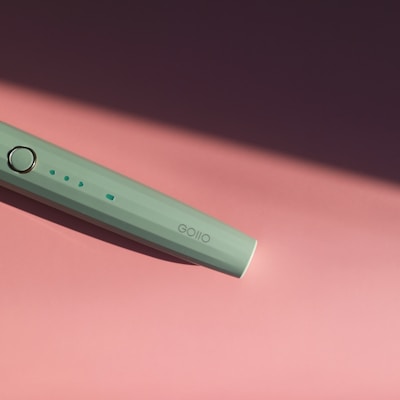 A calming mint green sound module glowing softly beside a storybook.