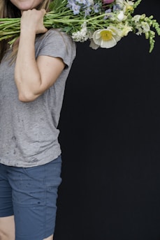 A delivery person holding a bouquet ready to deliver.