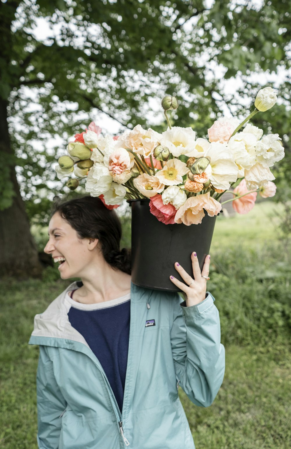 Frau in blauem U-Ausschnitt-Hemd mit Blumenstrauß