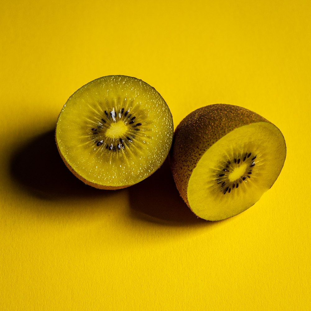 fruits verts tranchés sur une surface jaune