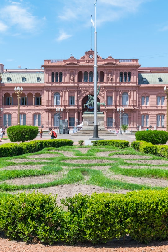 green grass field near white concrete building during daytime in Casa Rosada Argentina