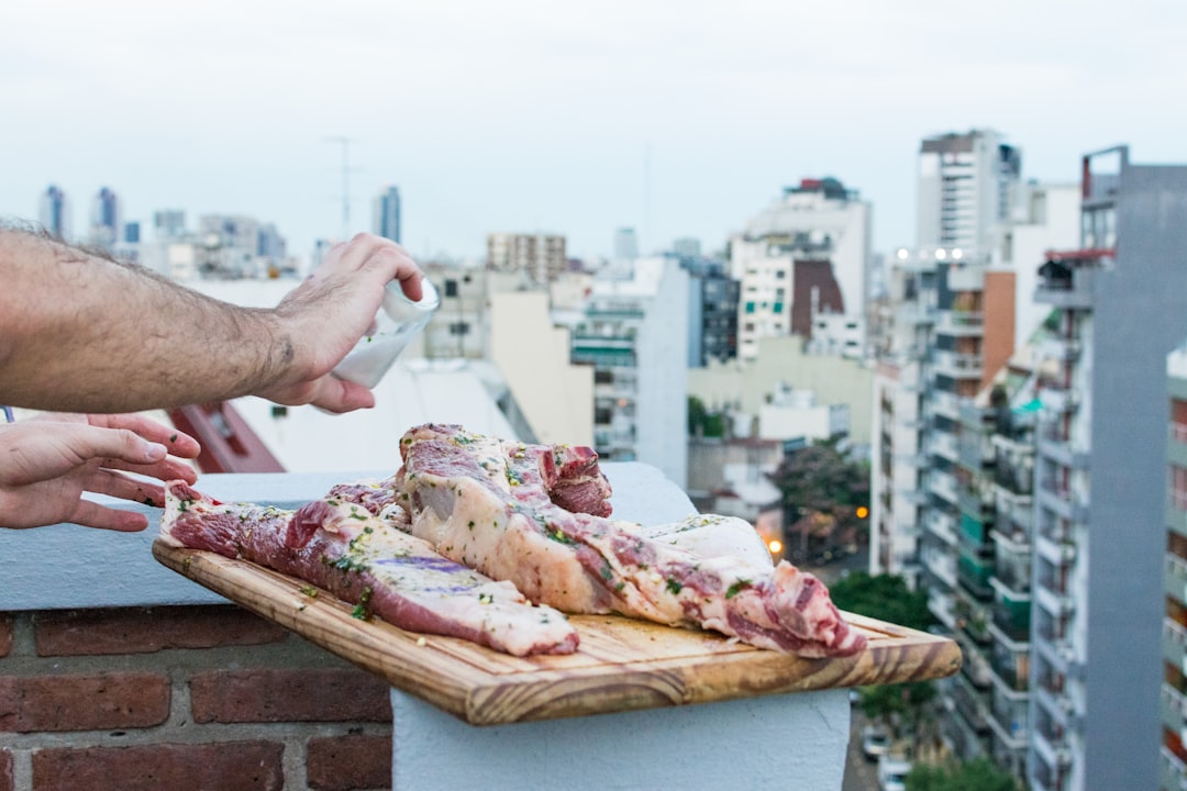 person holding sliced pizza on brown wooden table during daytime