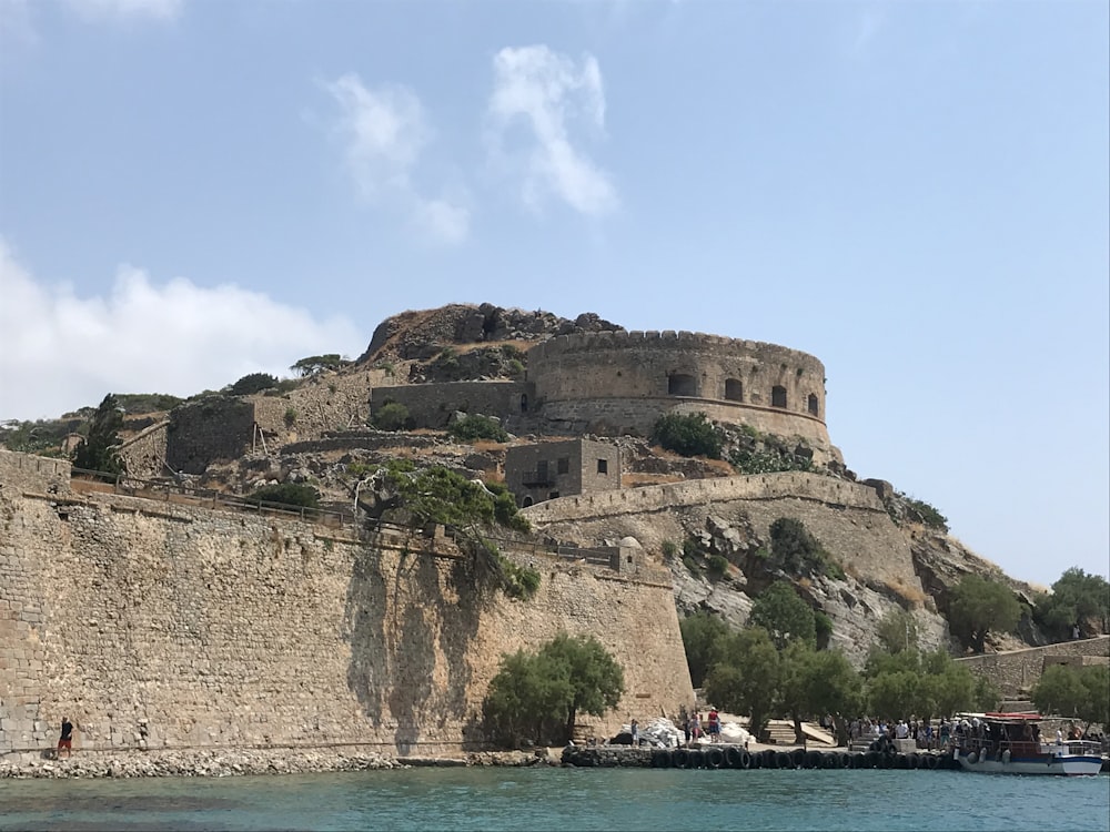 brown rock formation on sea under blue sky during daytime