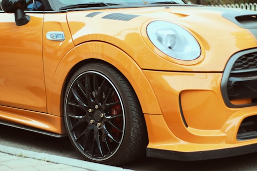 A sleek orange and black themed contact section with a phone and WhatsApp icon next to a car image