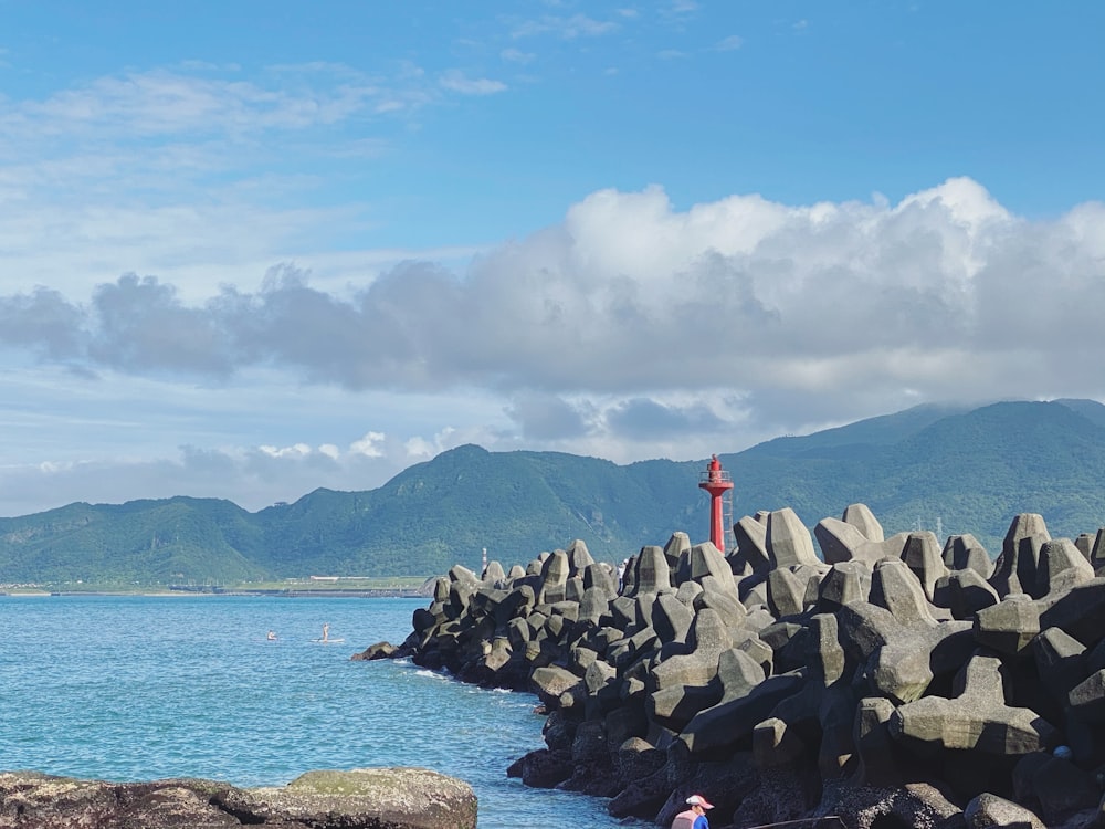 gray rocks near body of water under blue sky during daytime