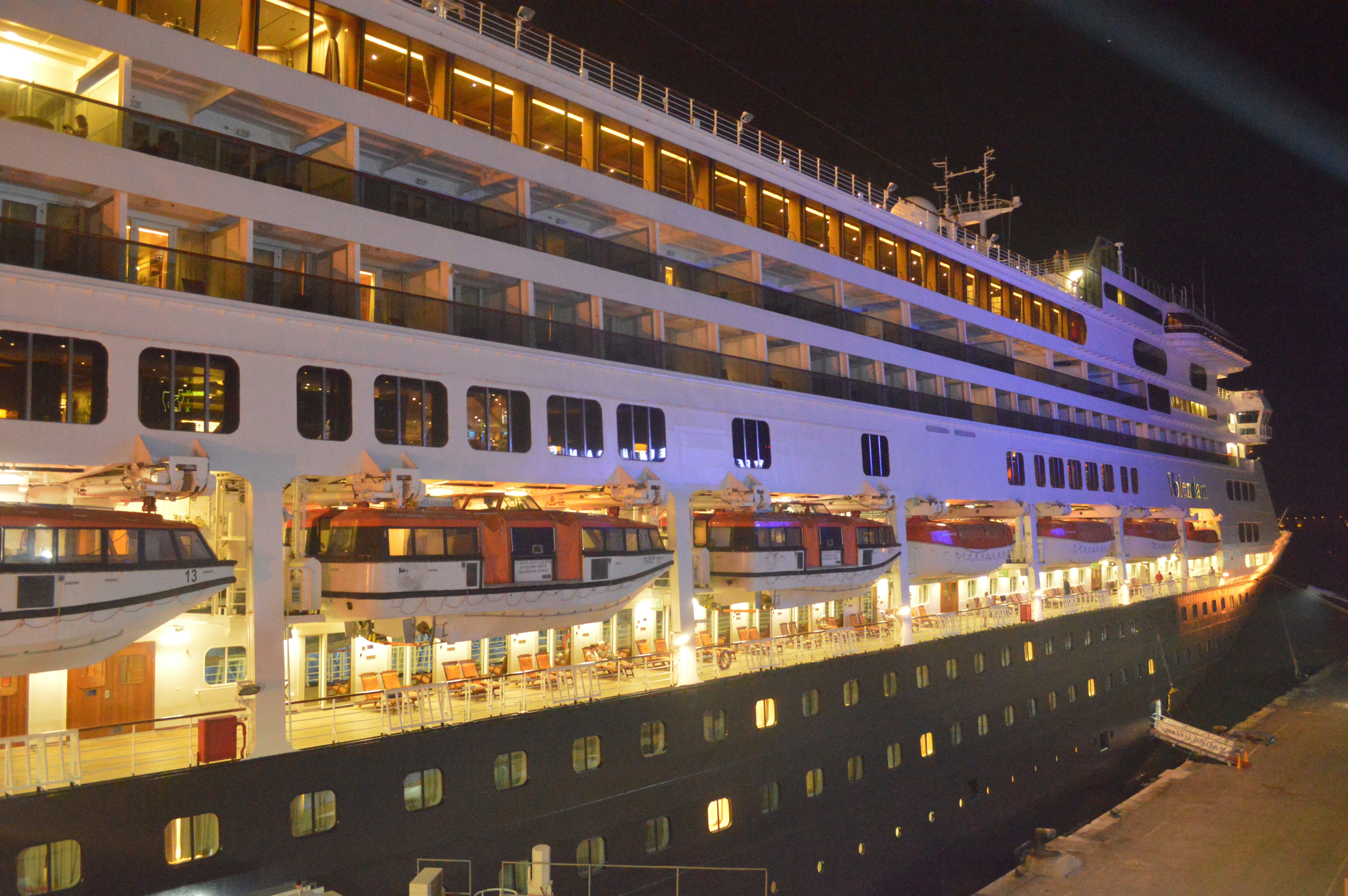 Tangier port at sunrise — large cruise ship docked, calm sea, amber light on harbor infrastructure