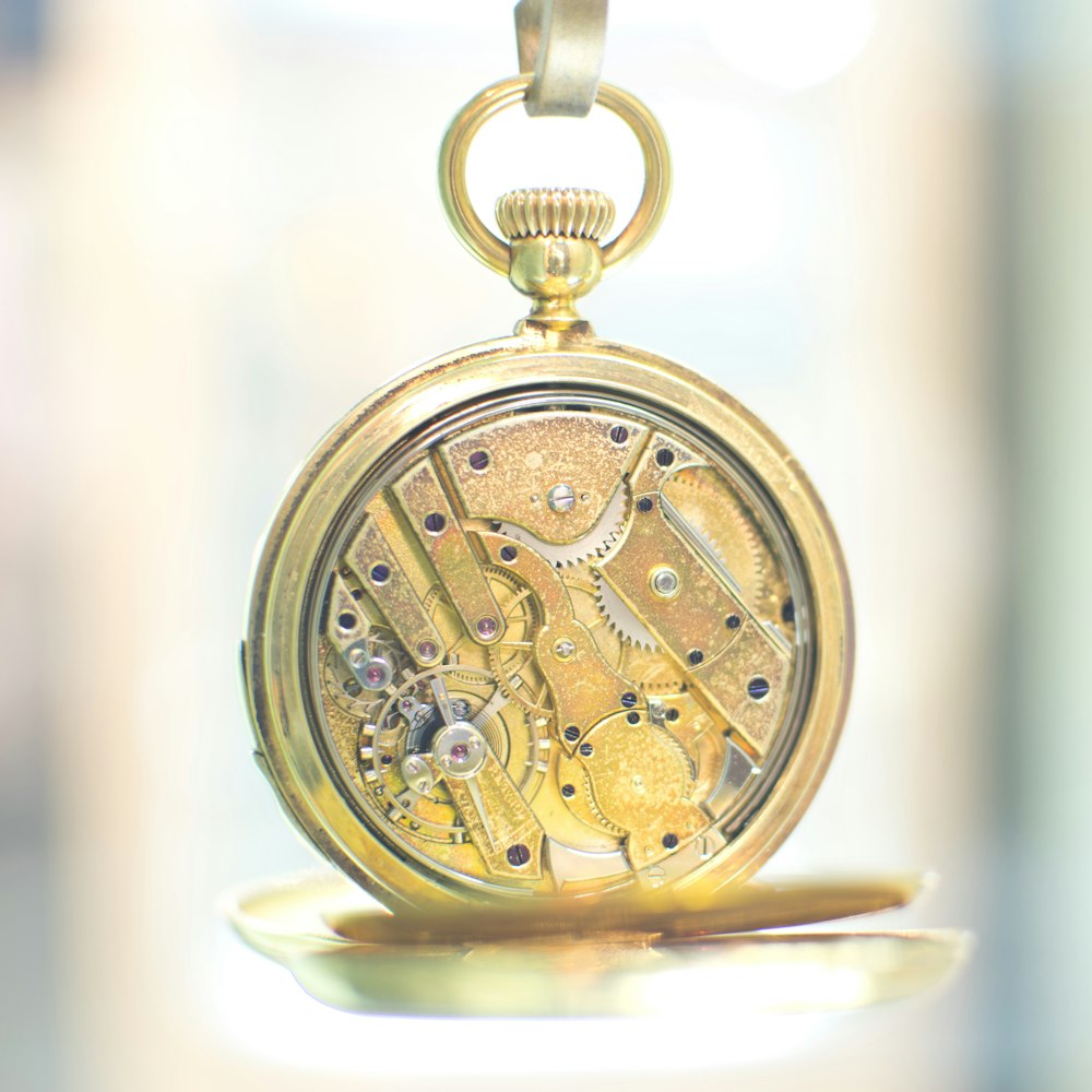 gold pocket watch on white surface