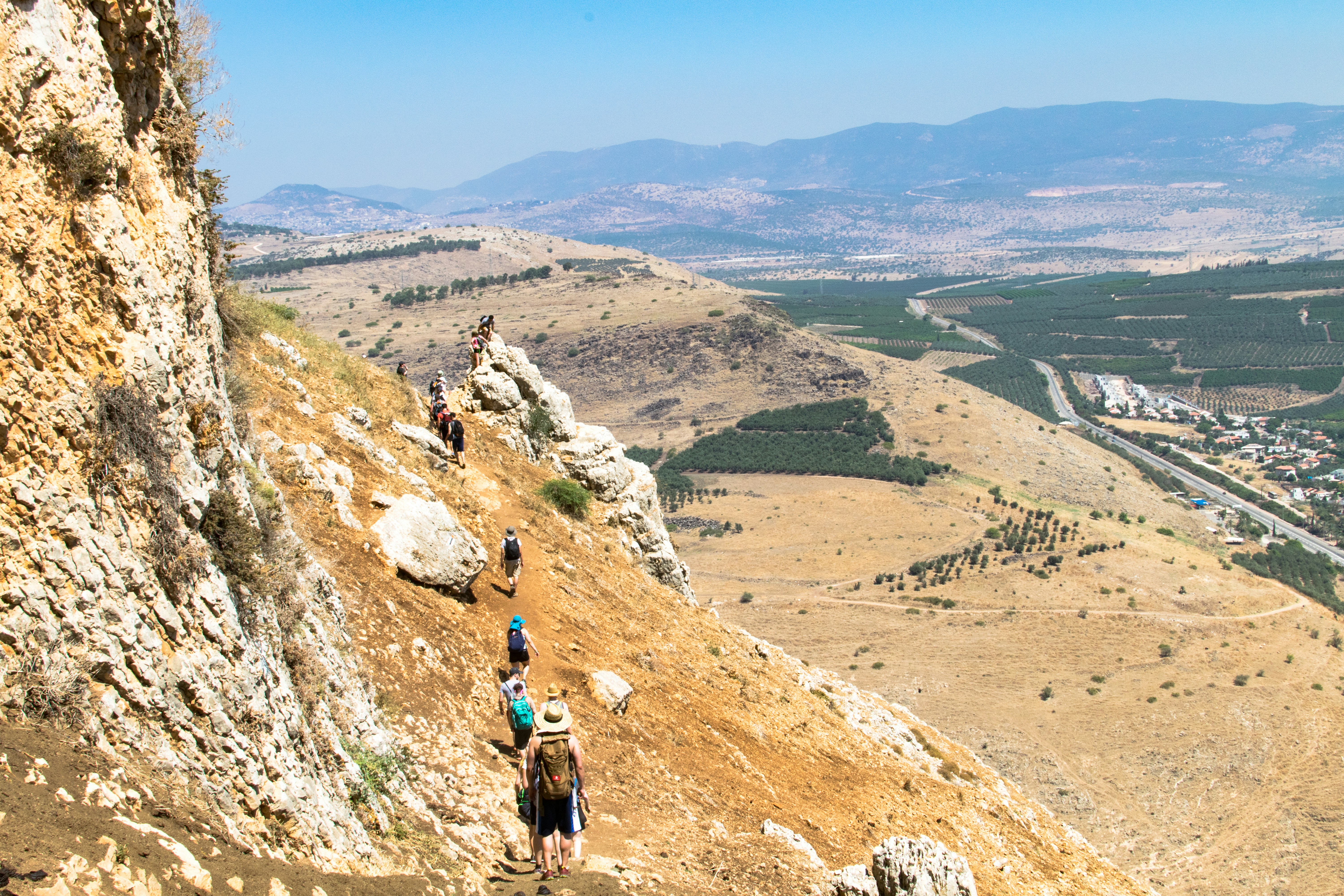 2 people hiking on rocky mountain during daytime