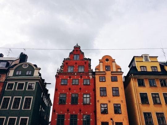 brown concrete building under white clouds during daytime in Stortorget Sweden