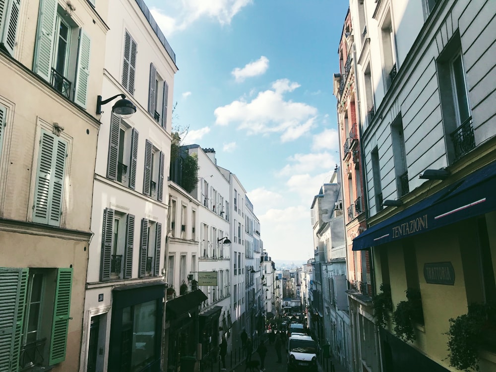 cars parked on street between buildings under blue sky during daytime