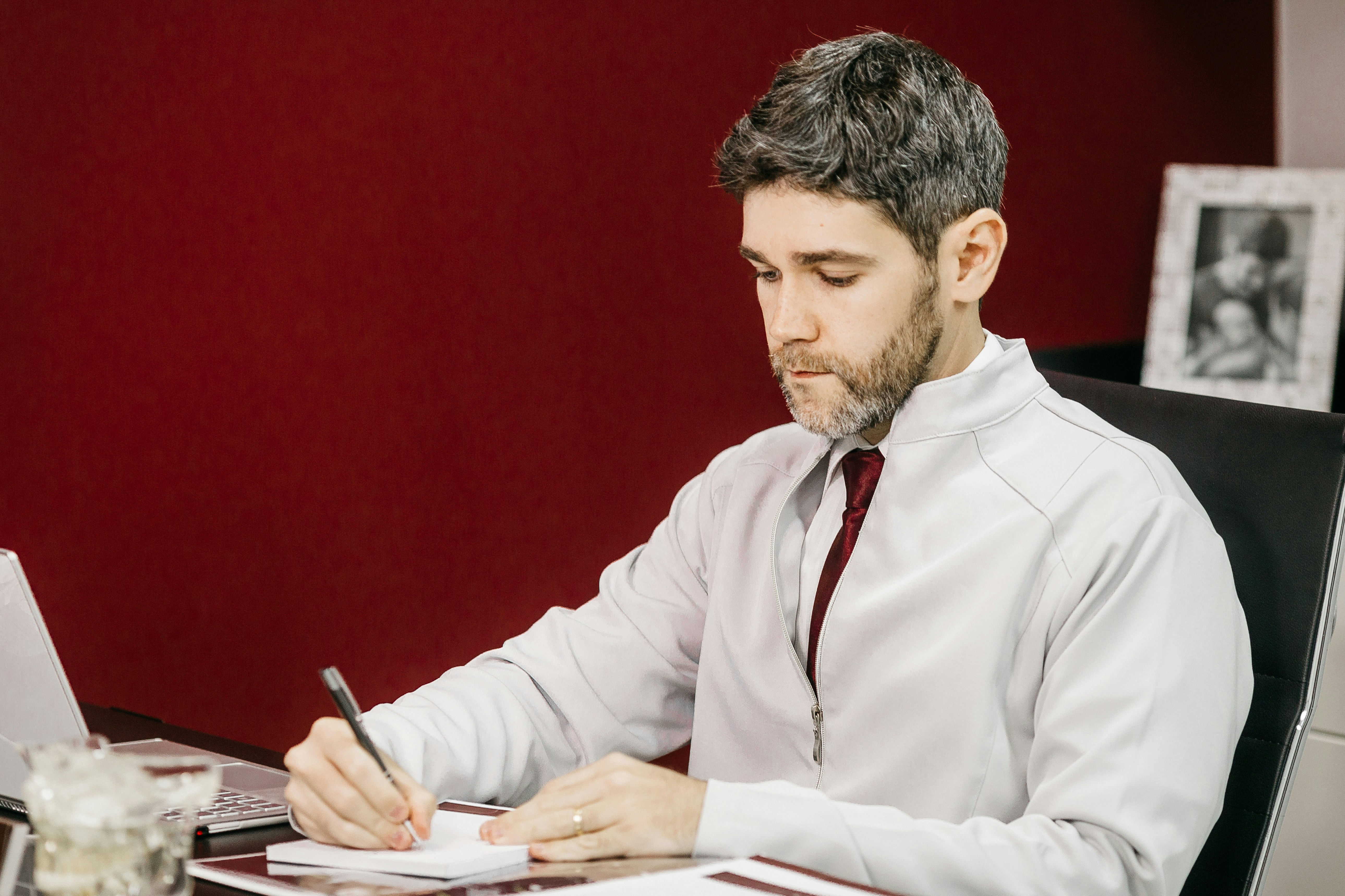 man in white dress shirt holding black pen
