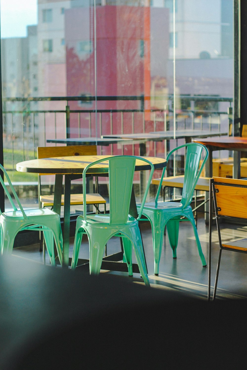 brauner Holztisch mit grünen Stühlen