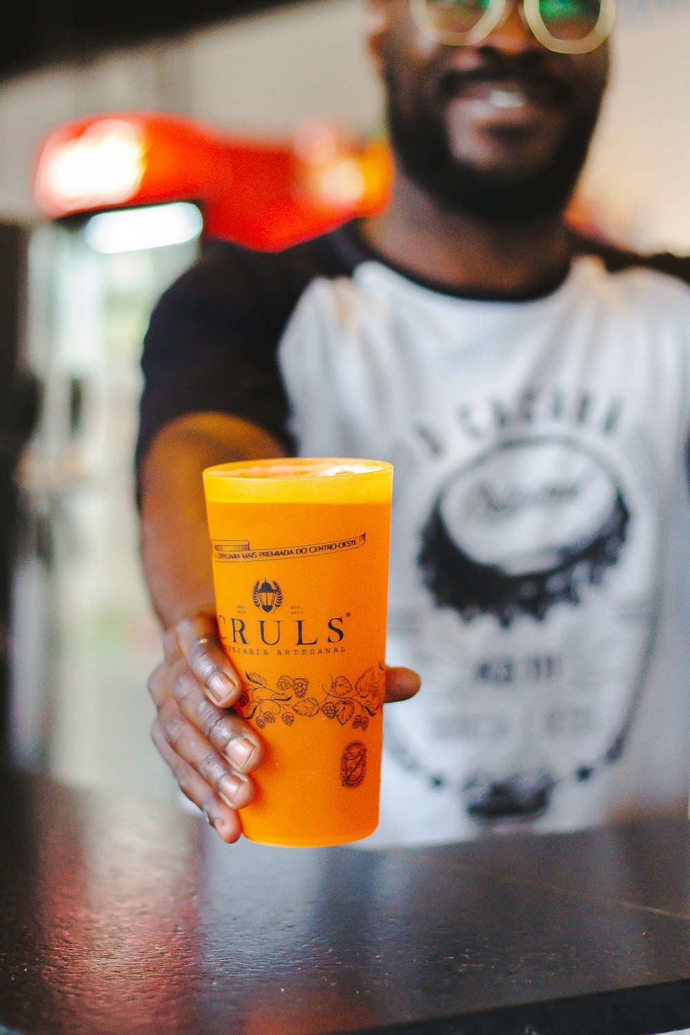 man in gray crew neck shirt holding orange cup