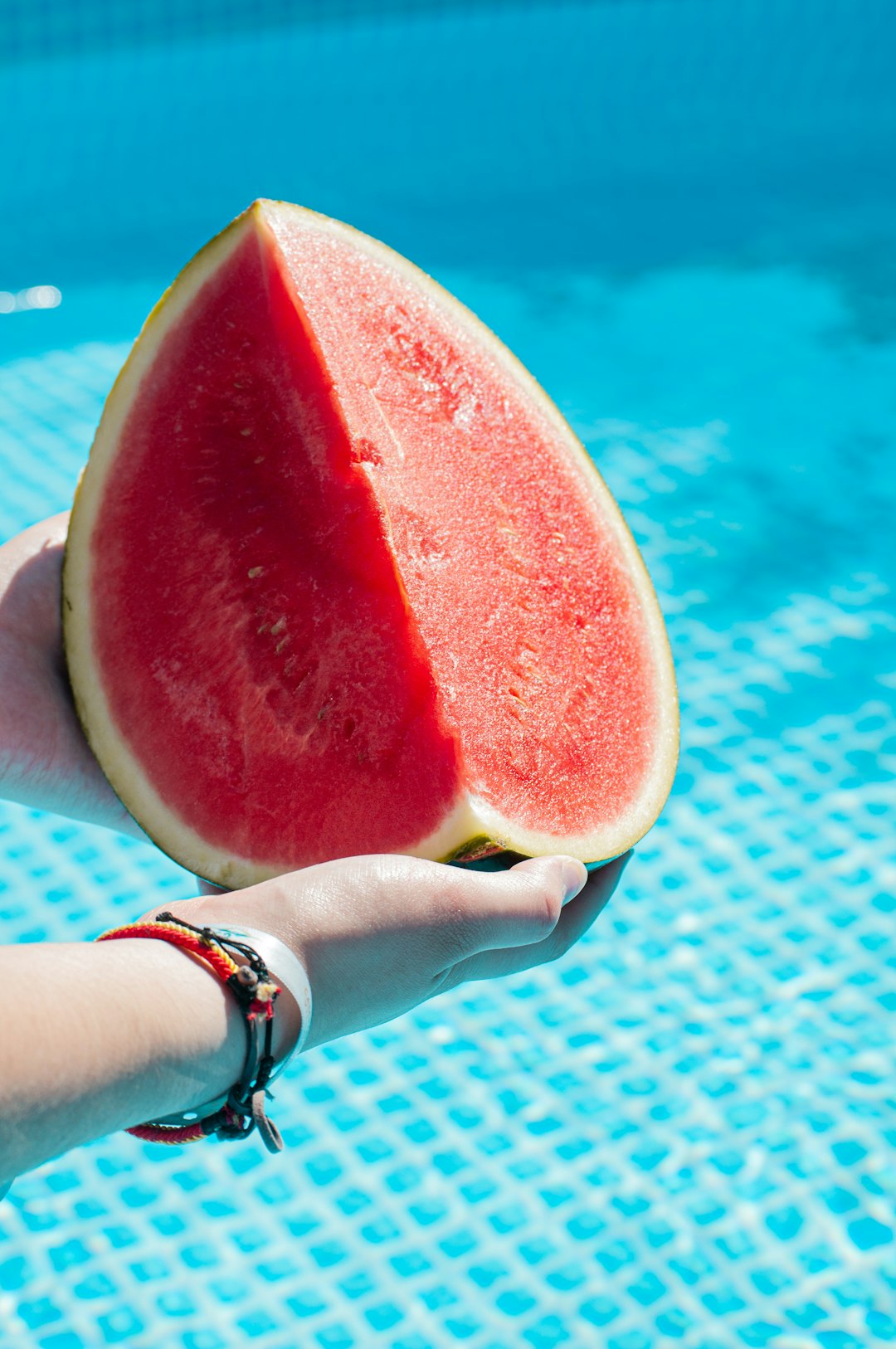 person holding watermelon in swimming pool