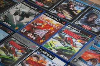A vibrant display of popular PS3 game covers stacked neatly next to a console controller
