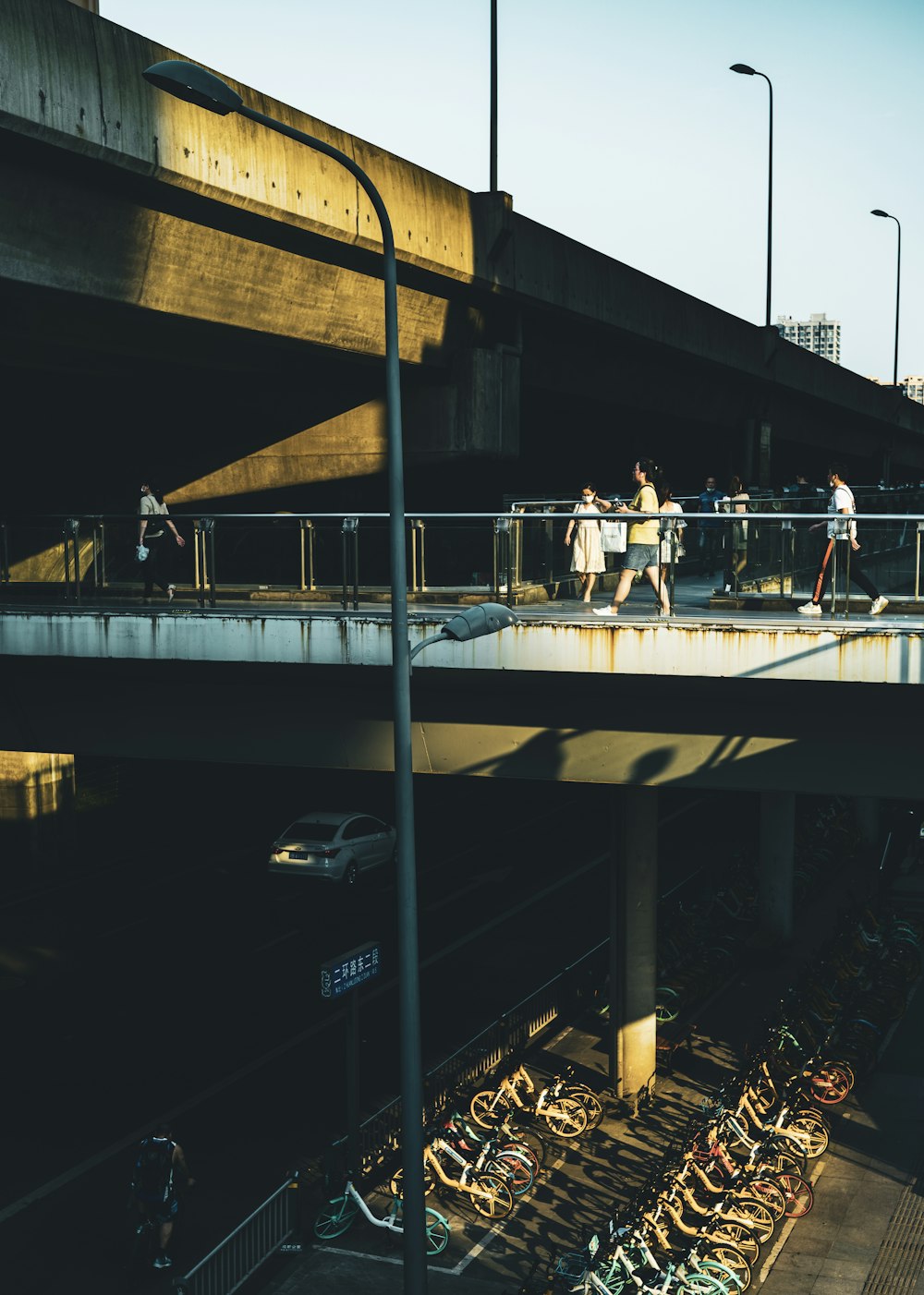 man in white shirt and black pants standing on bridge during night time