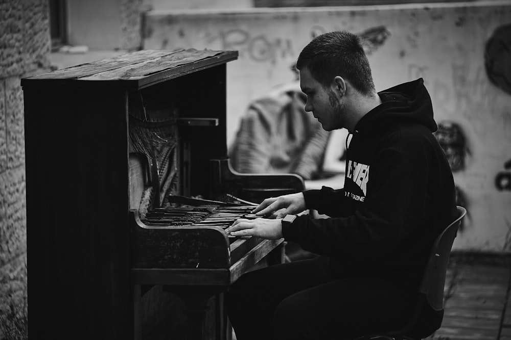 man in black long sleeve shirt playing piano