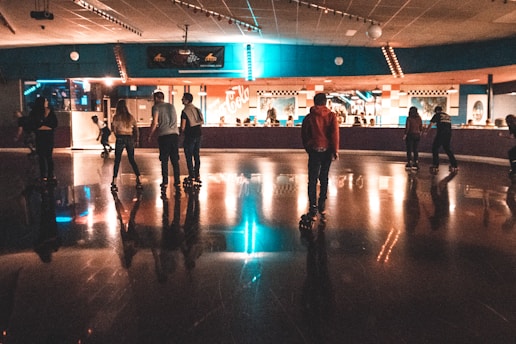 A young skater gracefully performing a spin on roller skates inside a bright indoor rink.