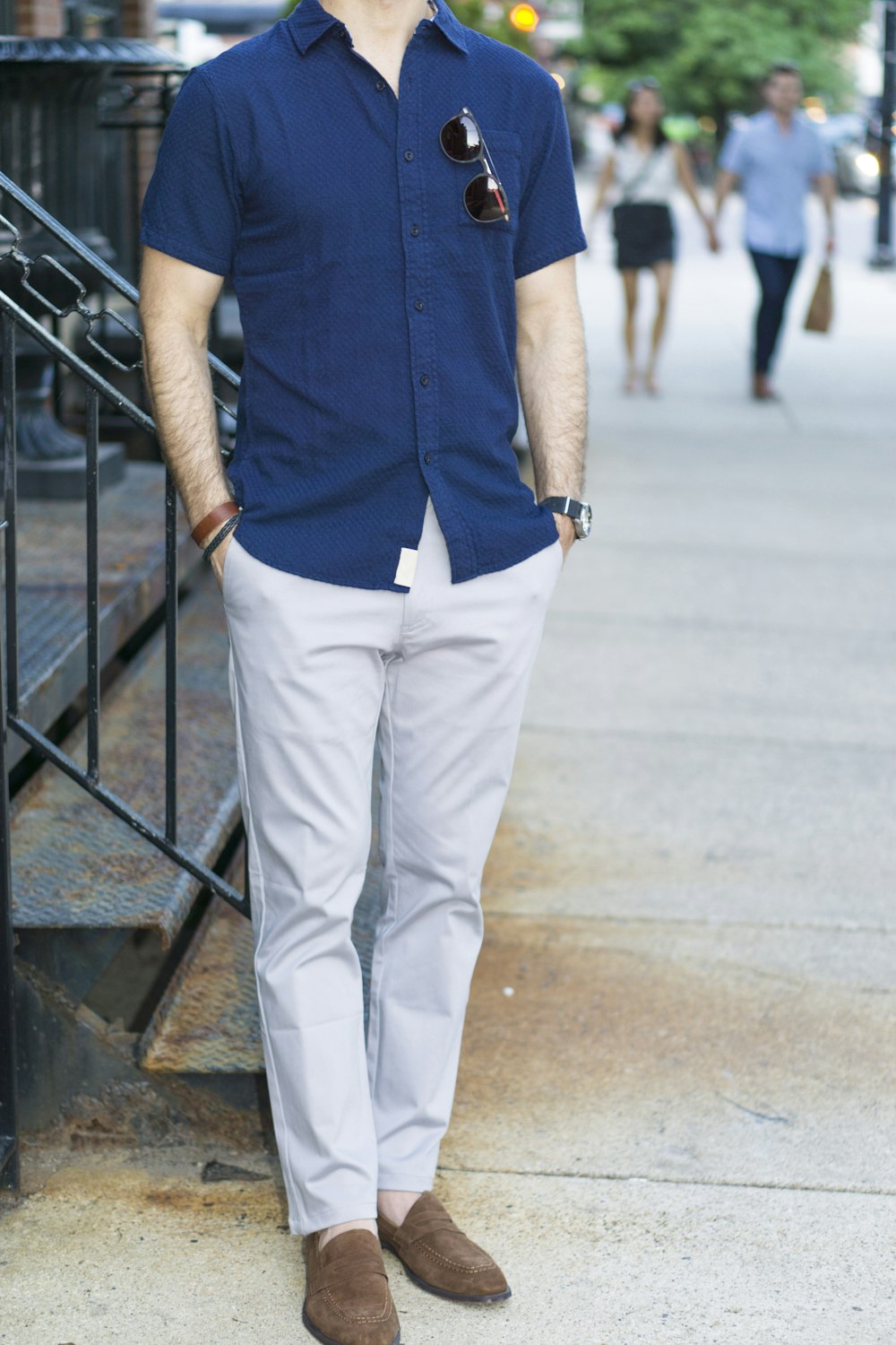 Person in blue button up shirt and white pants standing on gray concrete  floor photo – Free Il Image on Unsplash
