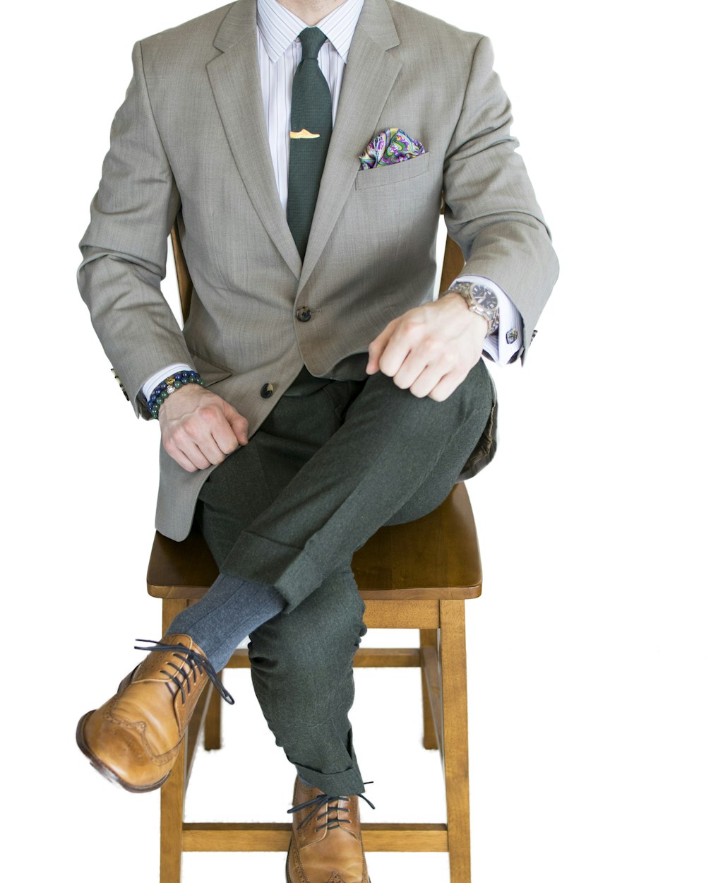 man in gray suit sitting on brown wooden chair