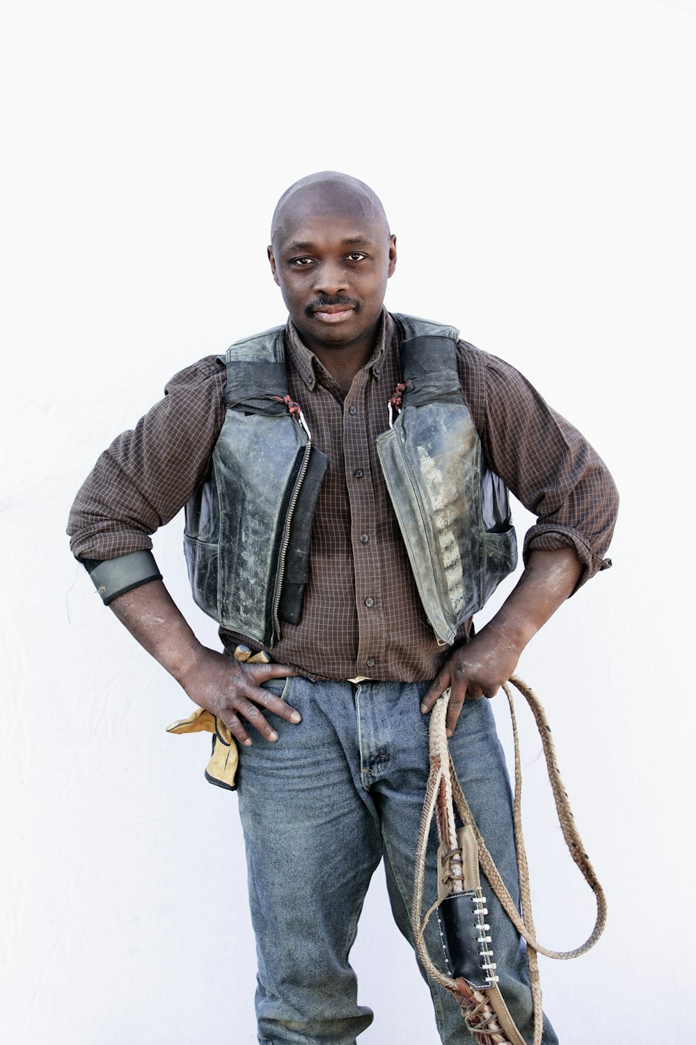 man in gray vest and blue denim jeans