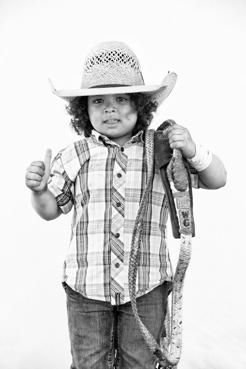 foto em tons de cinza do menino que usa o chapéu do cowboy