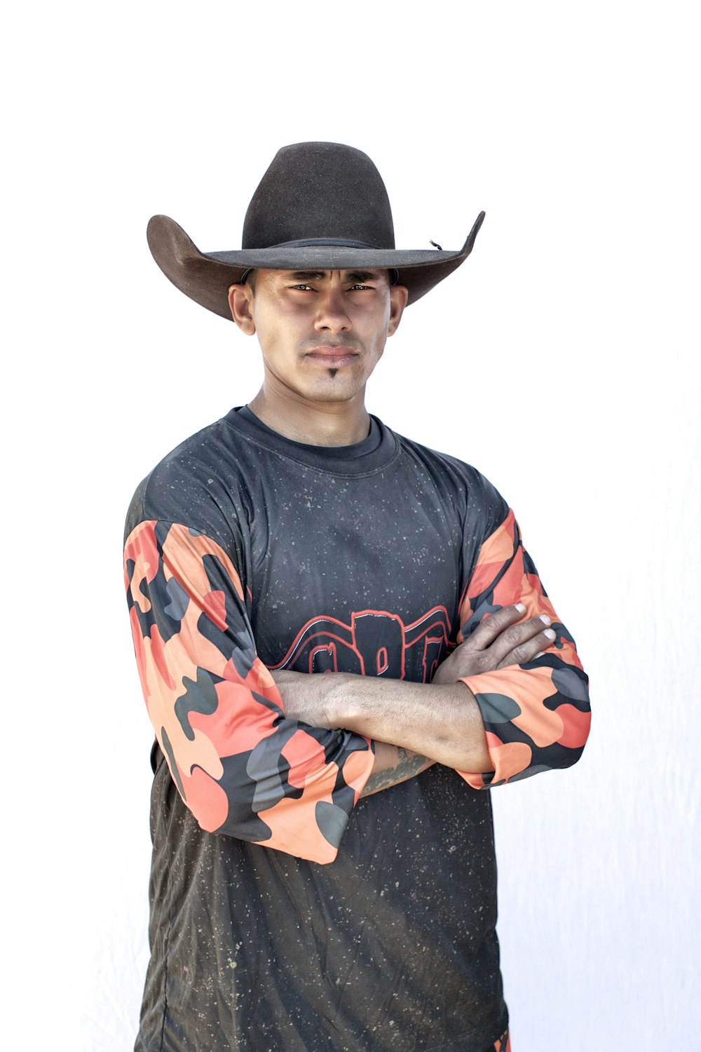 Homme en chapeau de cowboy noir et chemise à manches longues à col rond noir rouge et bleu