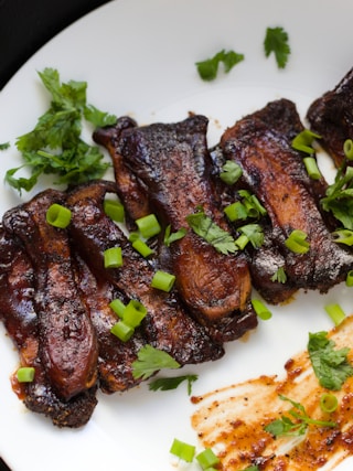 cooked meat with vegetable on white ceramic plate