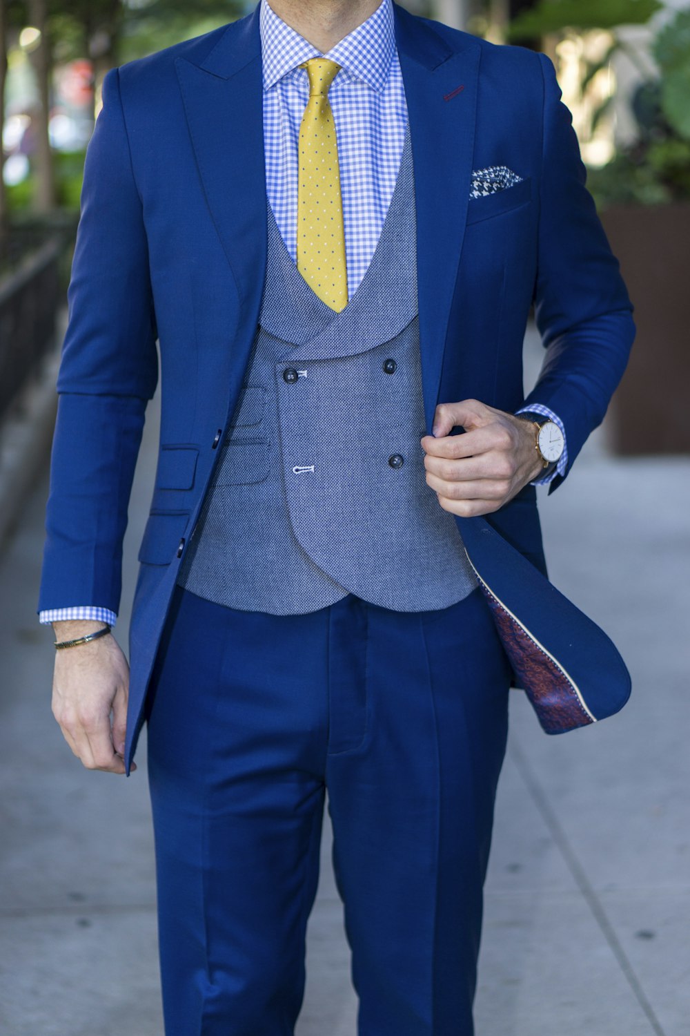 man in blue suit standing on road during daytime