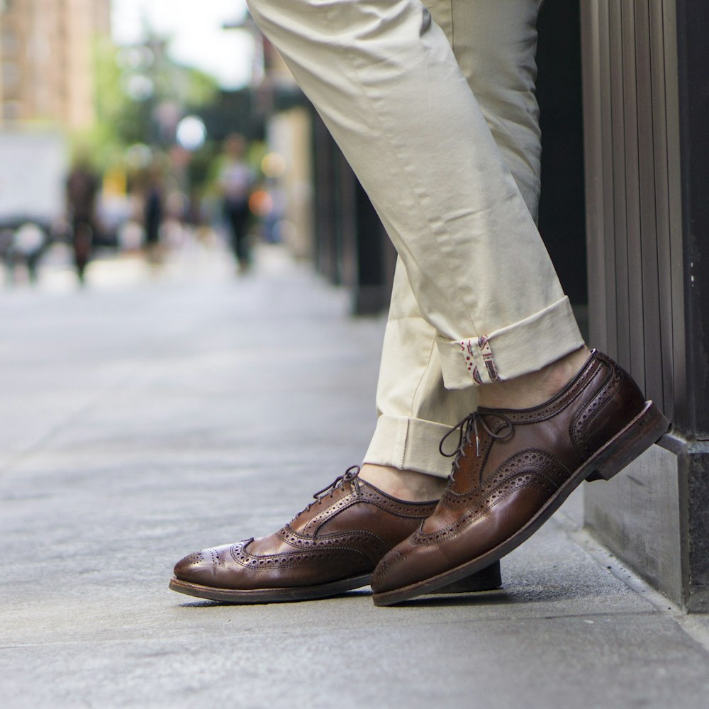 person in brown leather shoes and beige pants