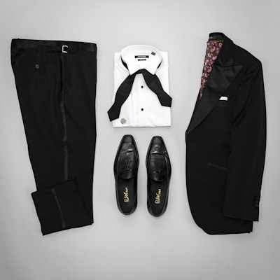 Casual men's outfit featuring a crisp white shirt and tailored black trousers, set against a chic urban backdrop.