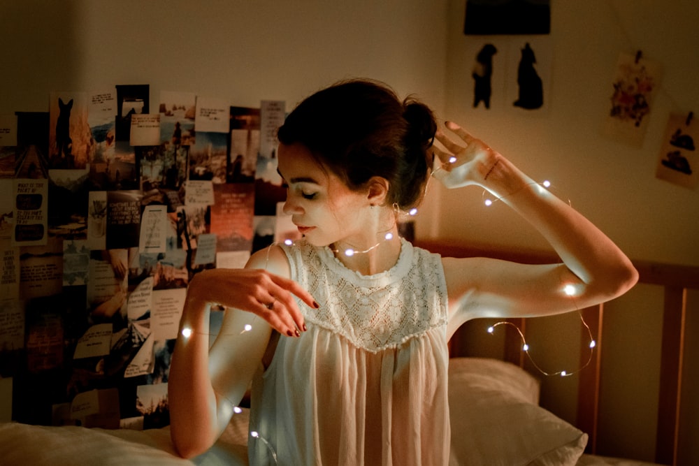 woman in white lace dress holding clear glass bottle