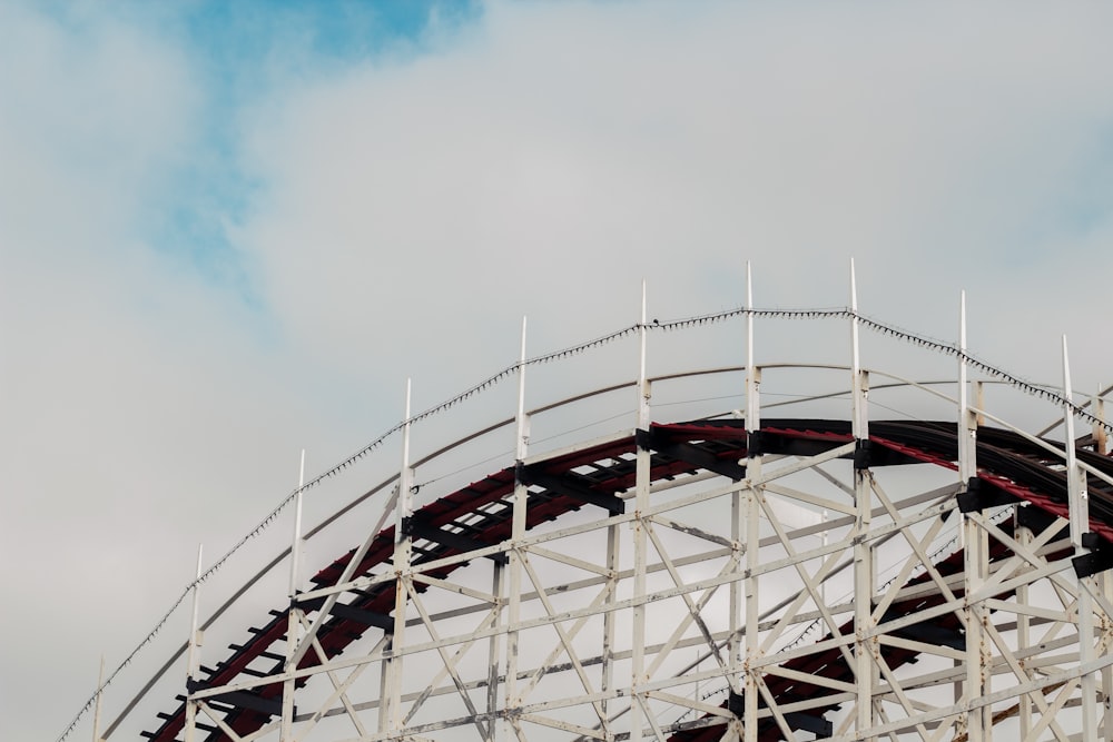 white and red roller coaster rail under blue sky during daytime