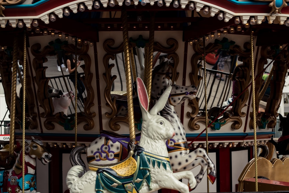 white horse carousel with people