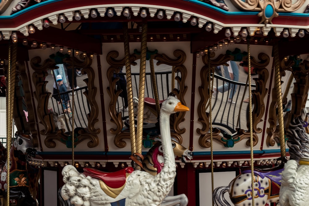 white and red carousel with birds