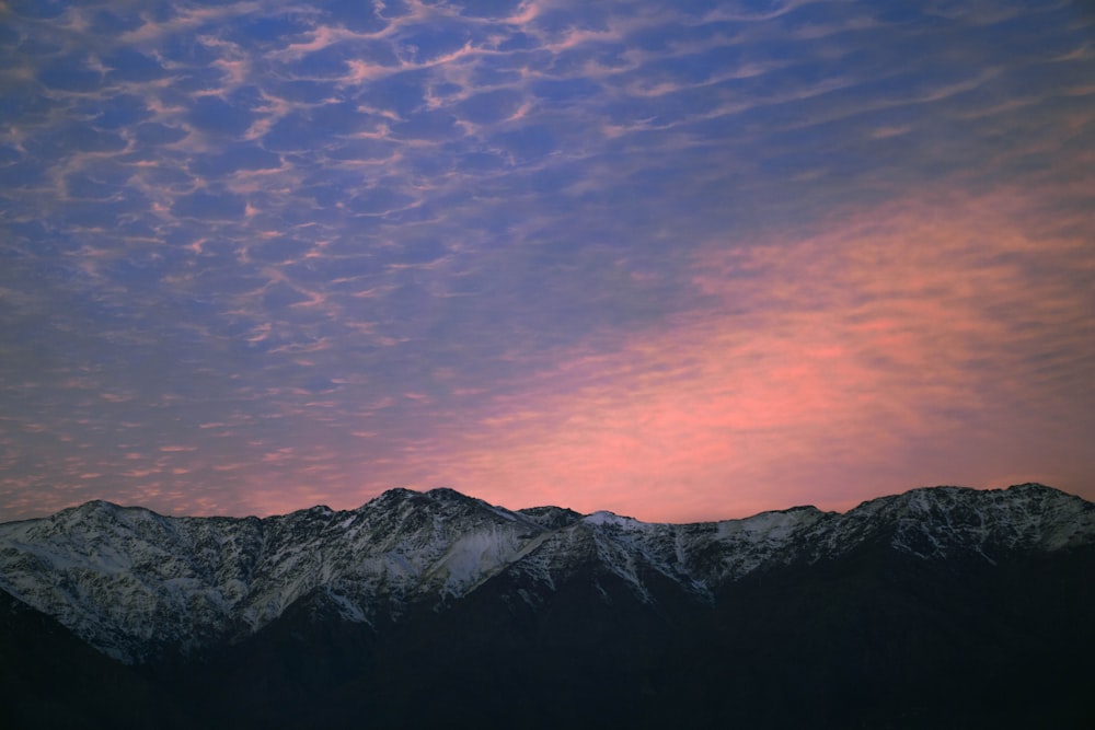 black and white mountain under orange and blue sky