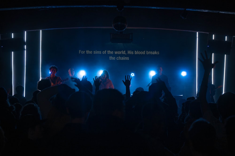 people standing on stage with lights turned on during nighttime