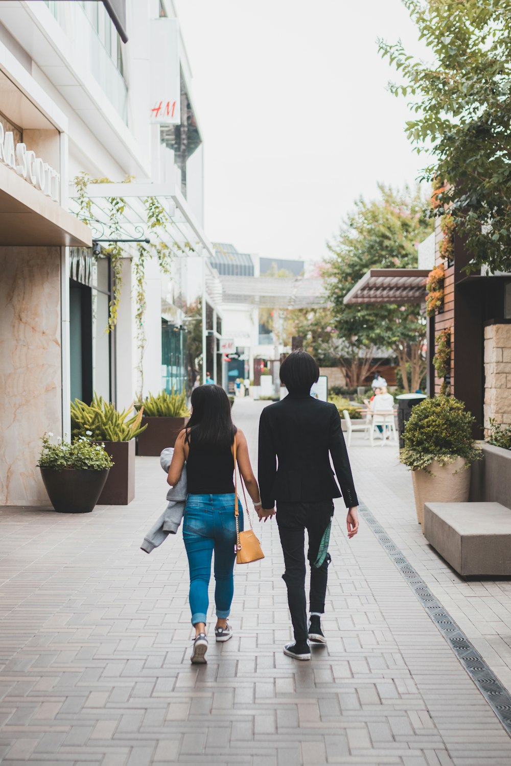 man and woman walking on sidewalk during daytime