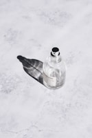 Close-up of a sleek Fazza Perfumes bottle with a minimalist label on a marble surface.