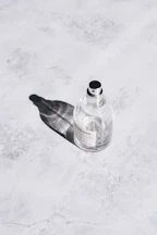 Elegant parfum mist bottle resting on a marble surface with natural light.