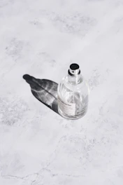Elegant parfum mist bottle resting on a marble surface with natural light.