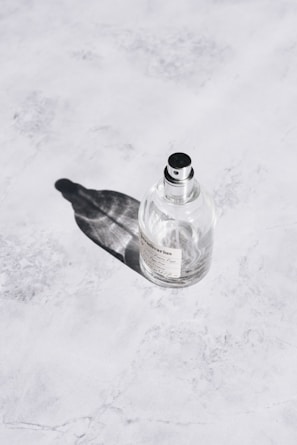 Close-up of a sleek Fazza Perfumes bottle with a minimalist label on a marble surface.