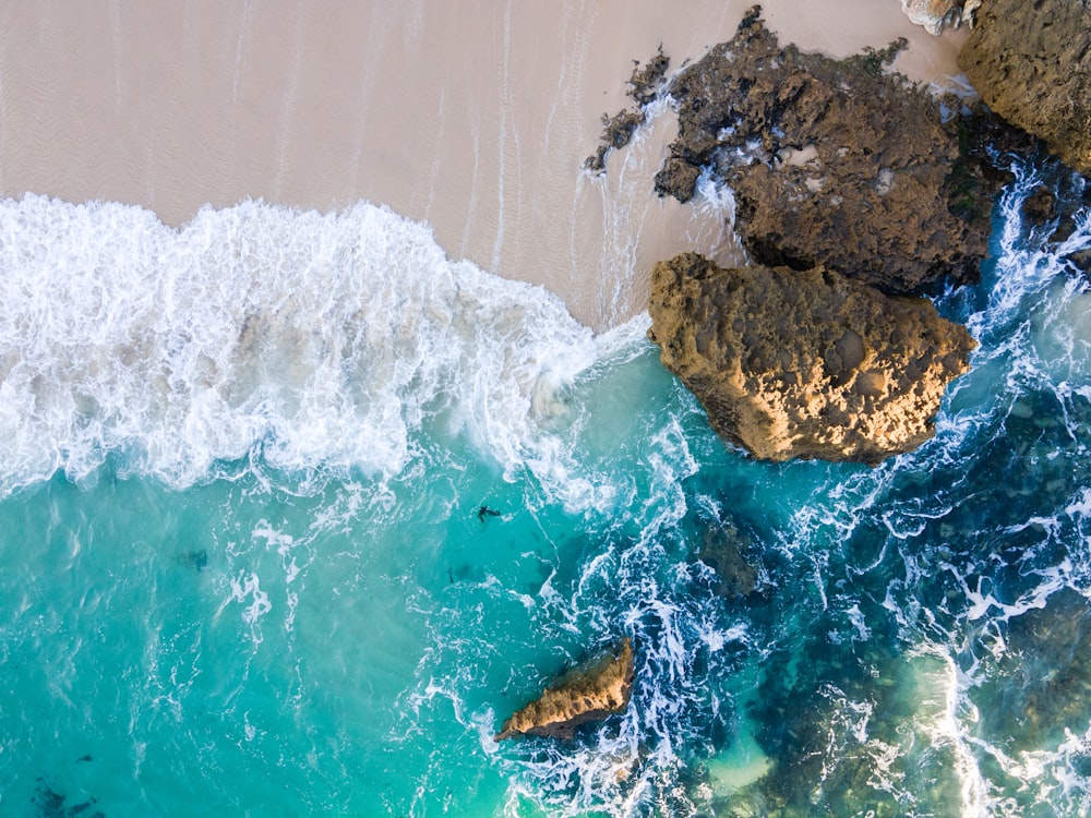 brown rock formation on body of water during daytime